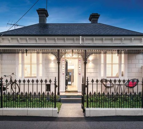 white brick house with black metal fence