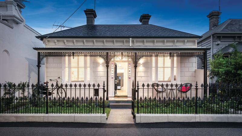 white brick house with black metal fence