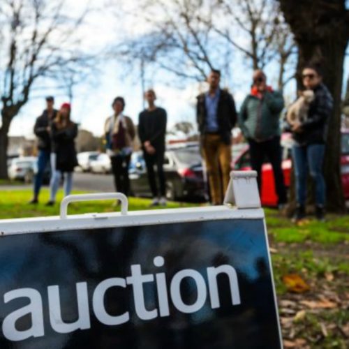 Auction sign with crowd in background