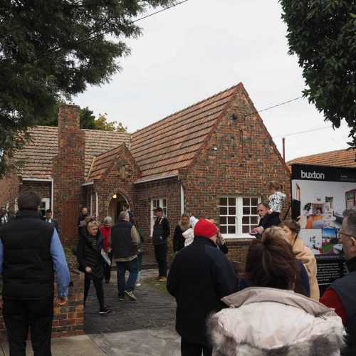 Auction snapshot - Auction in front of brown brick house