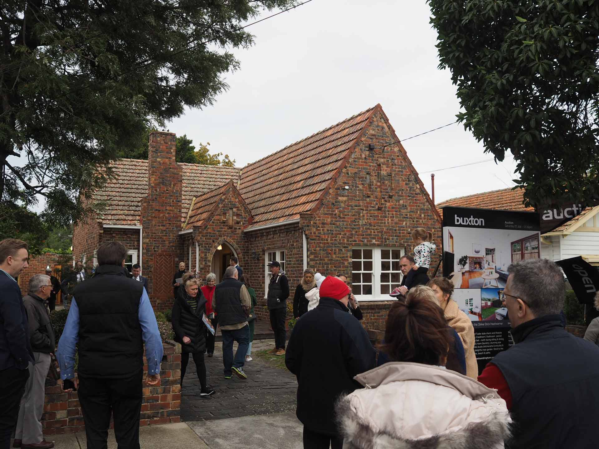 Auction snapshot - Auction in front of brown brick house