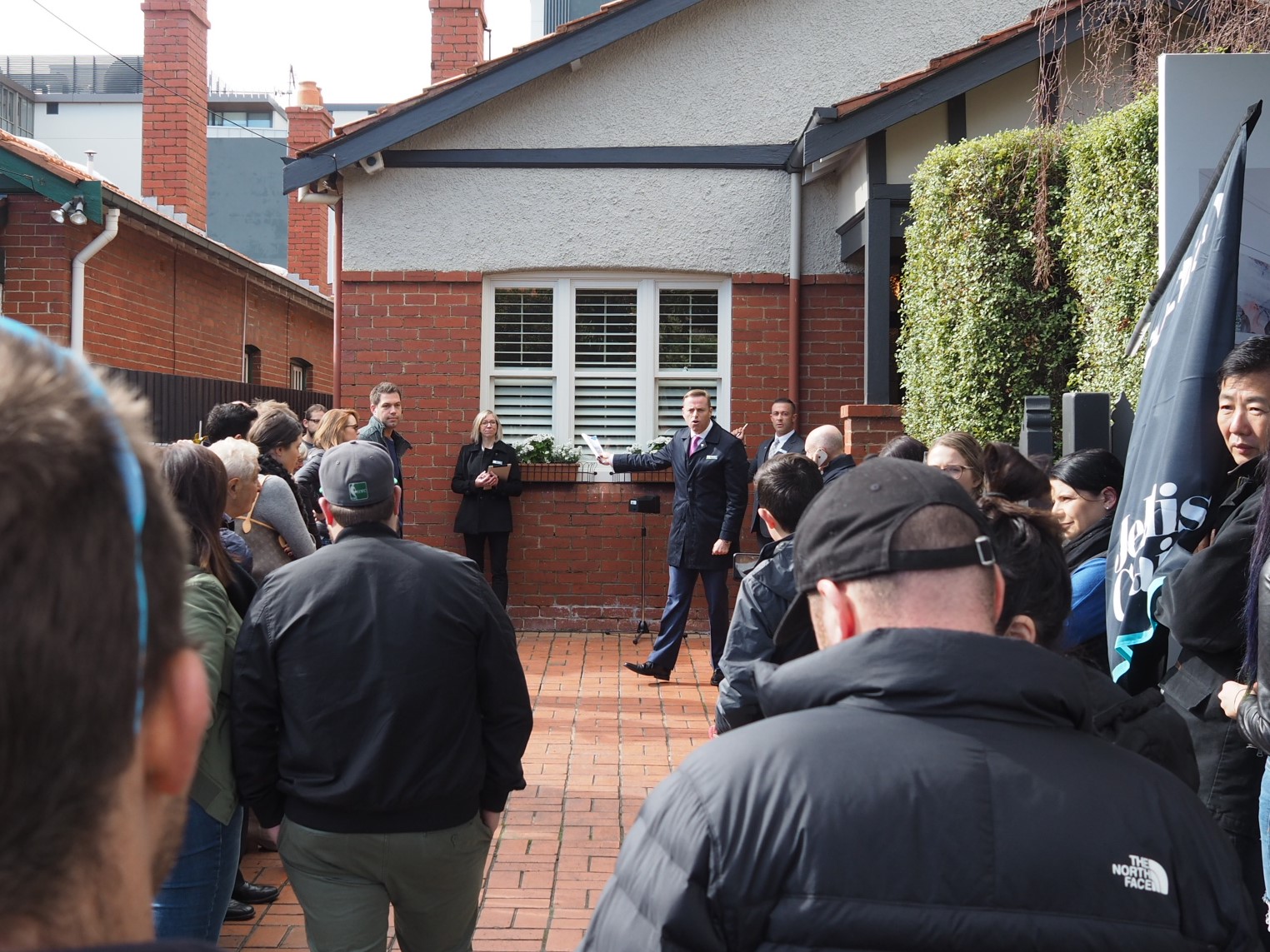 Auction snapshot - Auction in front of brick house