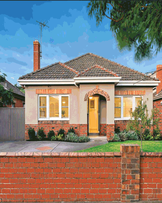 Small brick home with brick fence