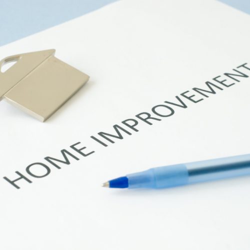 Home improvement document with pen and gold house pin