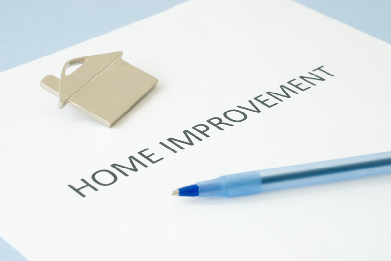 Home improvement document with pen and gold house pin